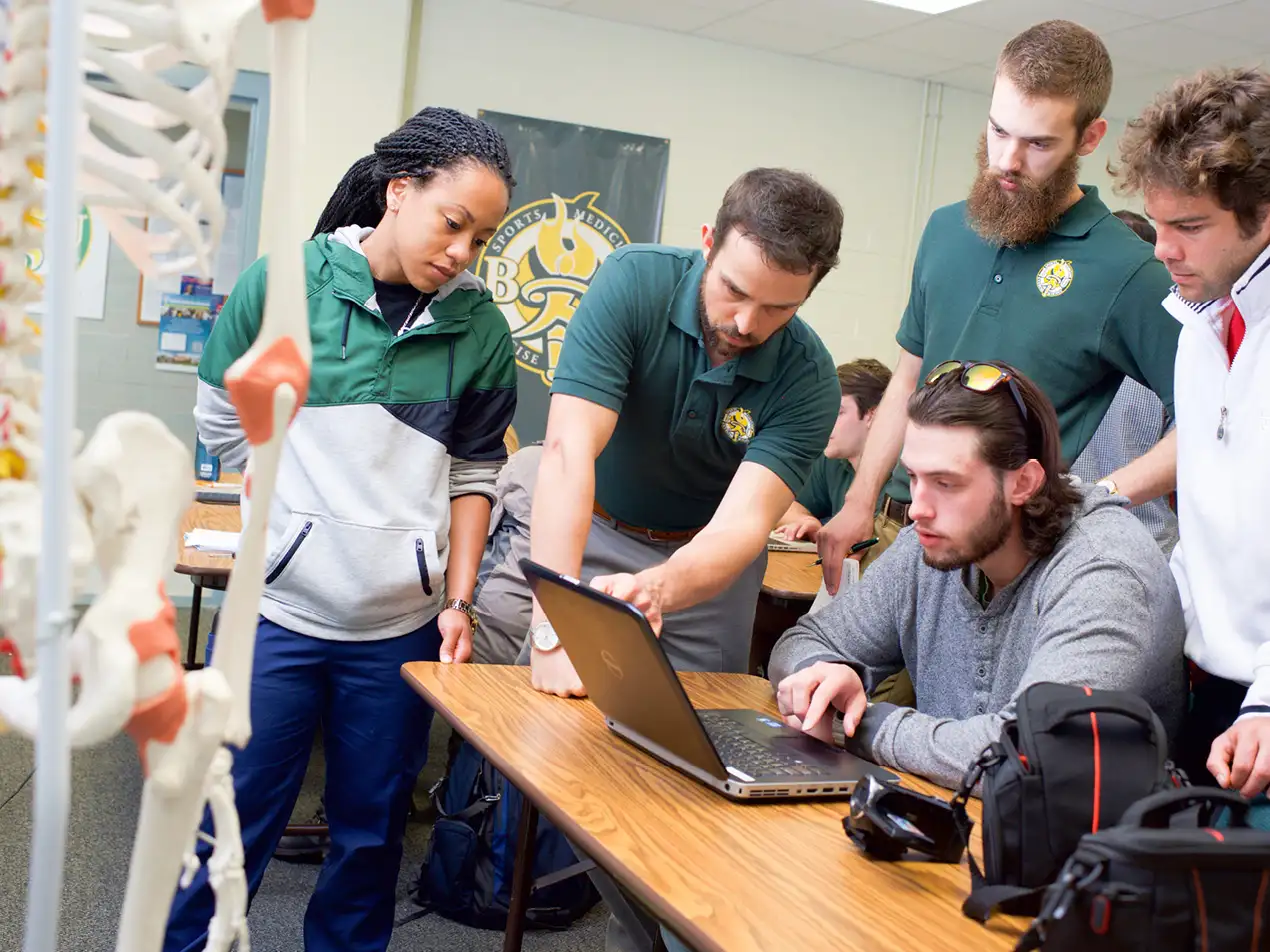 sports medicine students looking at a laptop